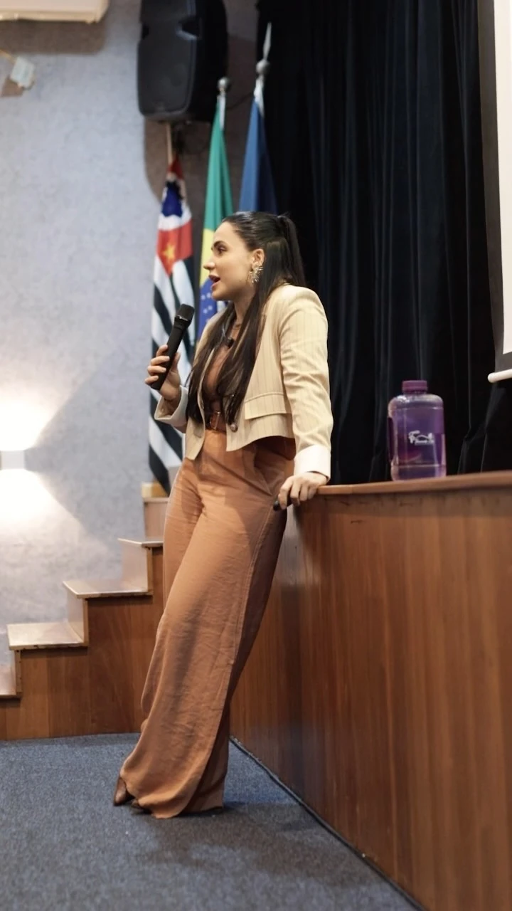 Fernanda Cosi dando uma palestra sobre nutrição, com microfone na mão